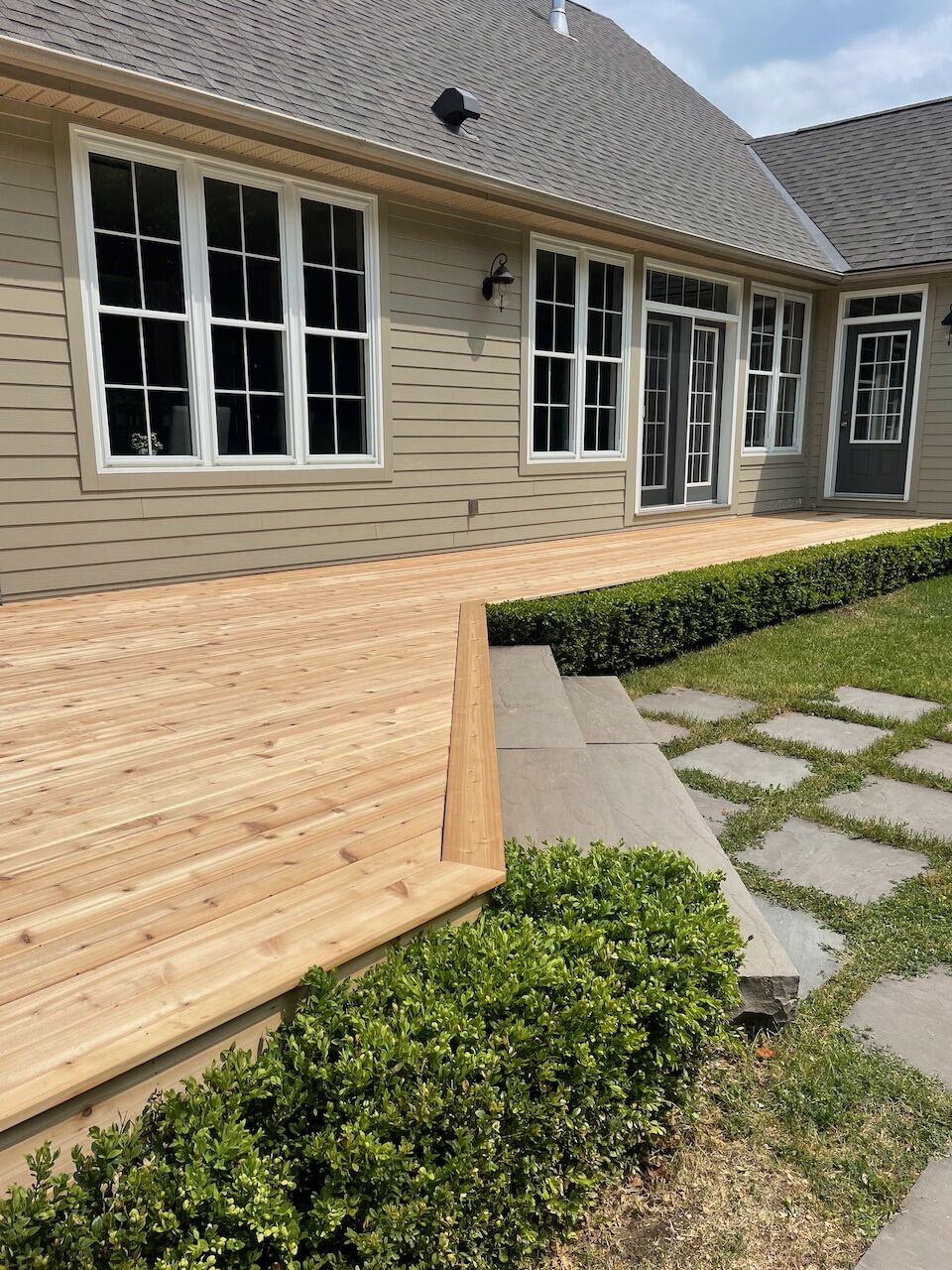 Fresh cedar deck boards laid with consistent reveals around a bungalow