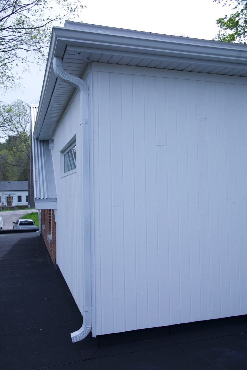 White-sided garage with new eavestrough
