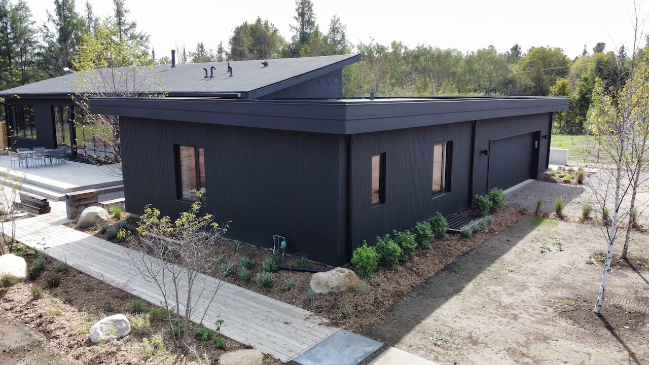 Modern dark-sided bungalow with stone walkway built by Escarpment Contracting