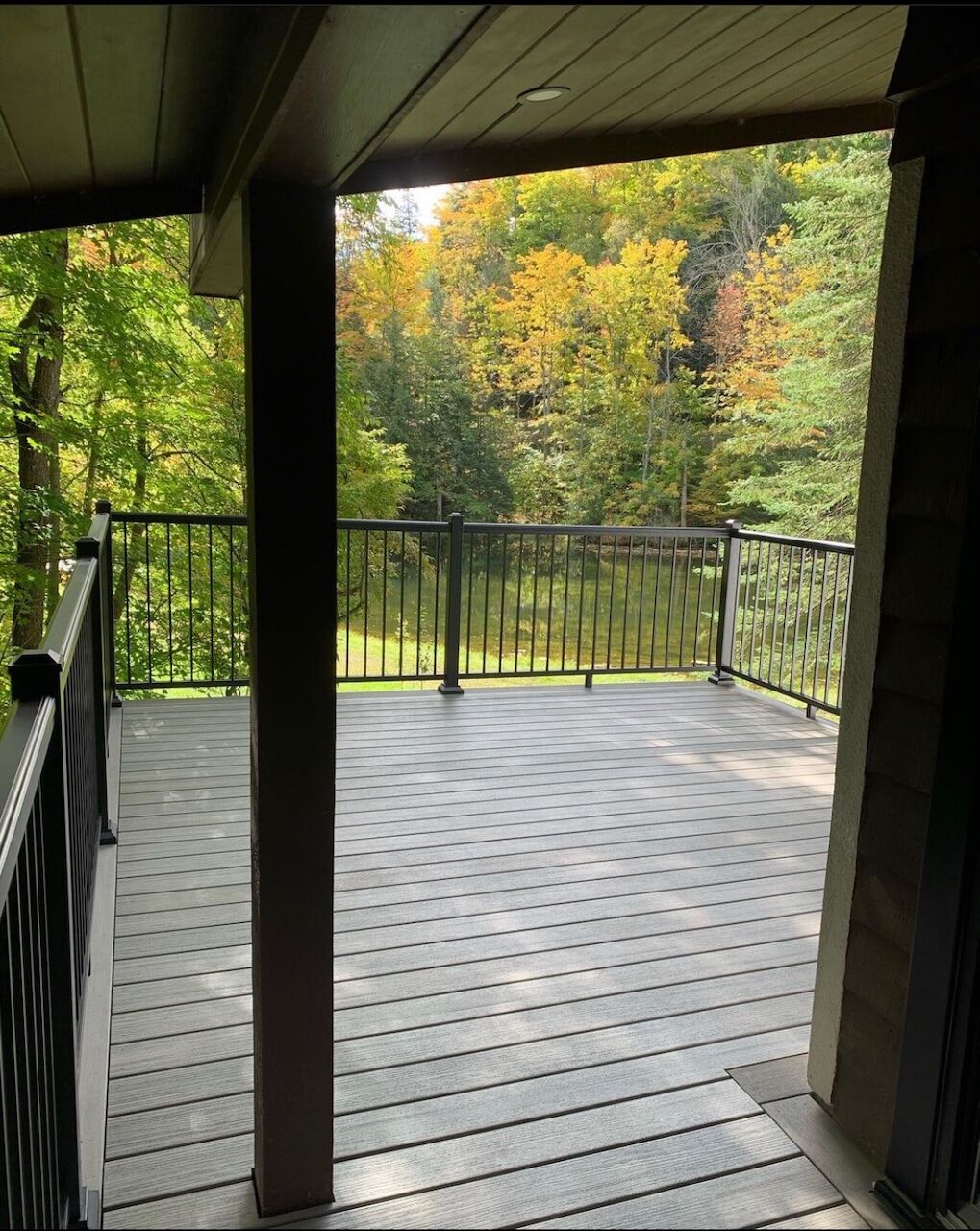 Covered porch with dark posts overlooking the water at Caledon Ski Club