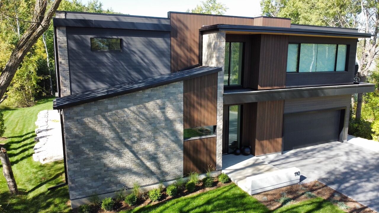 Modern two-storey home with dark siding and wood accents in Blue Mountains