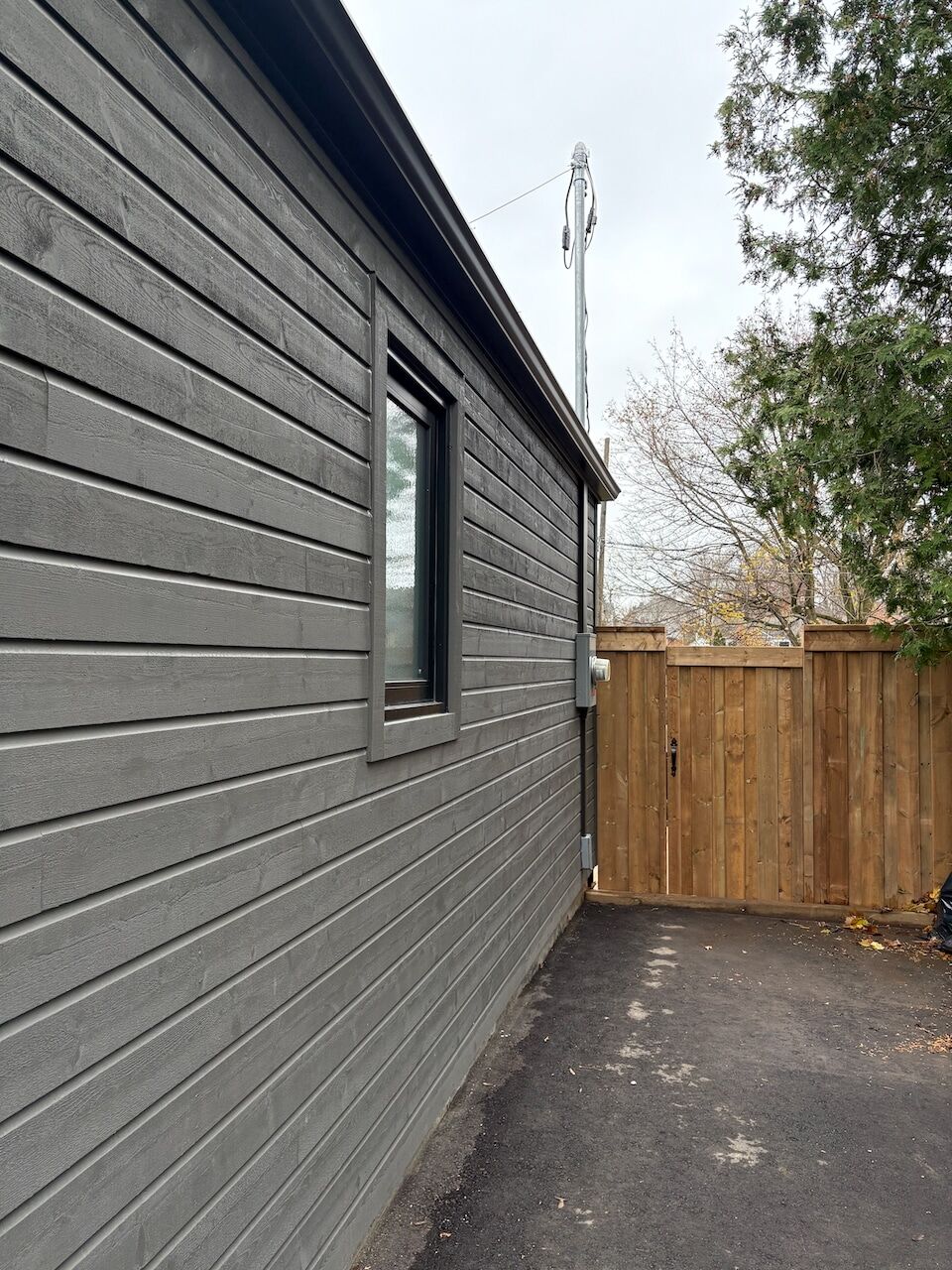 Dark vertical siding wall and matching fence gate detail