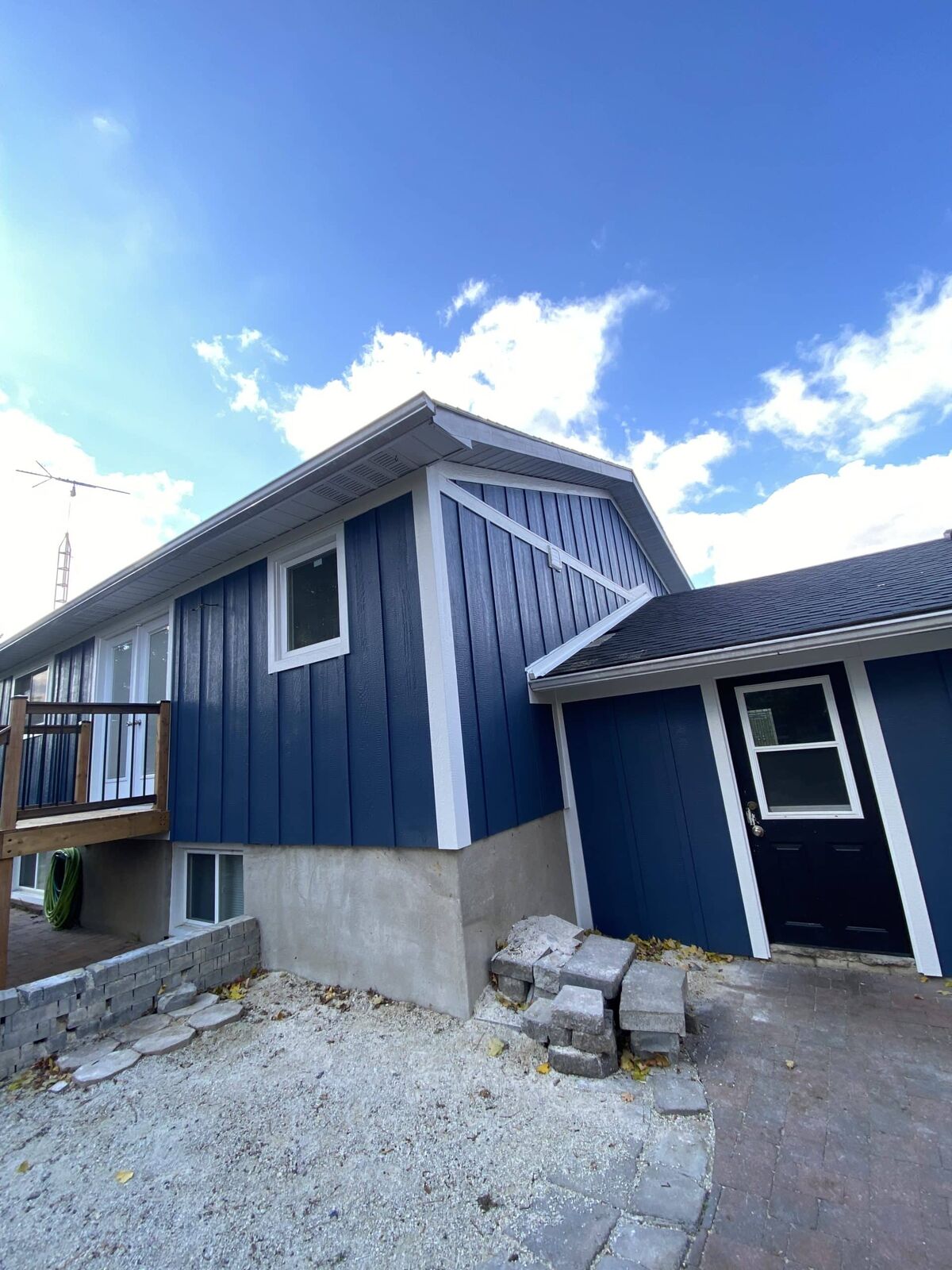 Navy siding and new deck under construction on a home in Erin