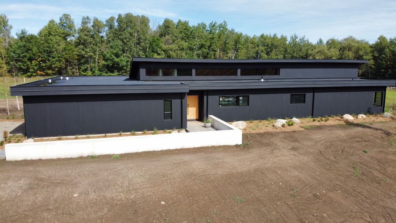 Long modern building with dark siding in Erin