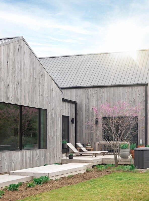 Weathered wood siding on a modern barn-style home on Wellington Rd