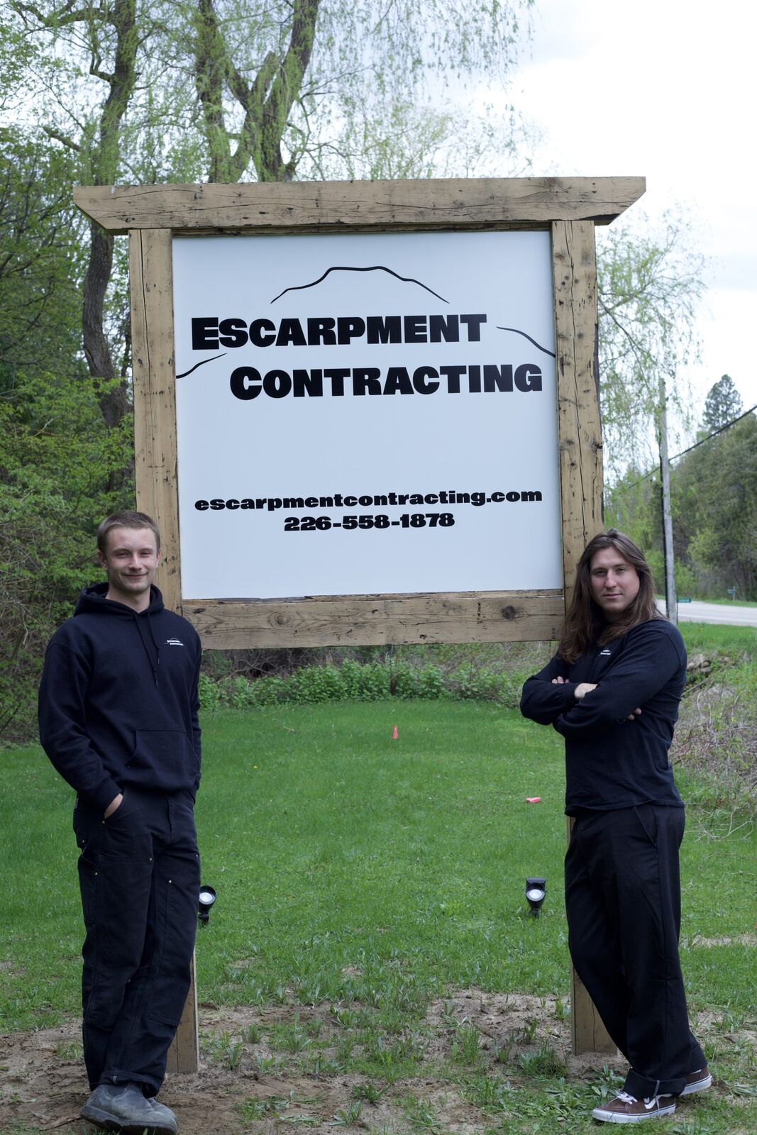 Escarpment Contracting owners standing with the company sign